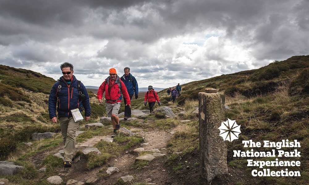 Photo of walkers in Peak District with English National Park Experience Collection logo overlay