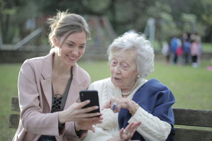 Older Woman And Younger Woman Using Mobile Device Aspect Ratio 720 480