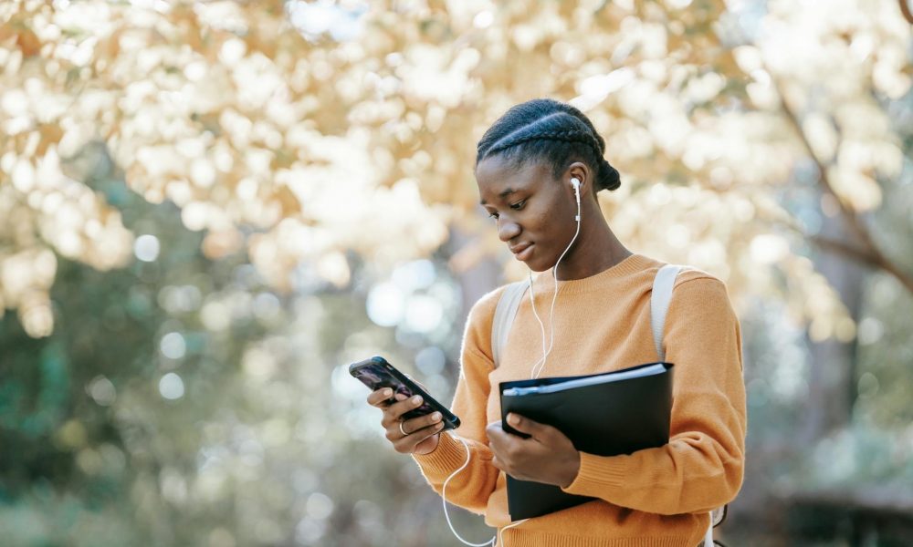 Woman Using Mobile Phone In Outdoor Setting Aspect Ratio 1000 600
