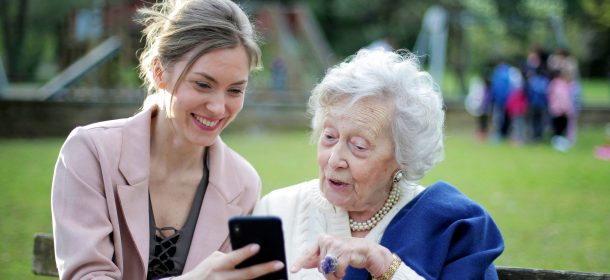 Older Woman And Younger Woman Using Mobile Device 1 Aspect Ratio 610 280