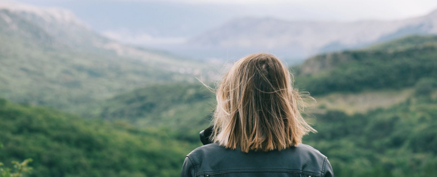Woman Looking Into Distance Oiutside Healthy Mountains Green Aspect Ratio 1440 585